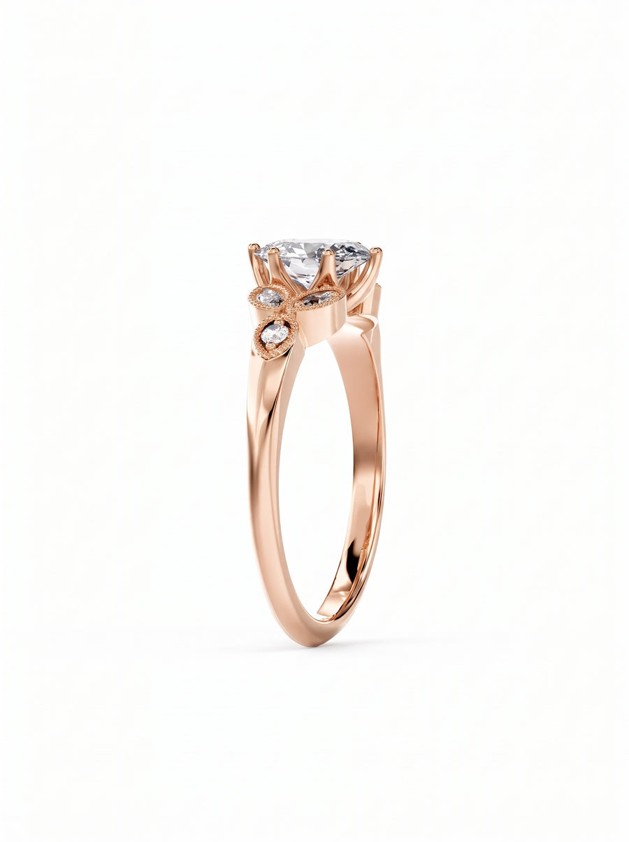 Rose gold engagement ring with an oval cut center diamond and small accent stones on the band.