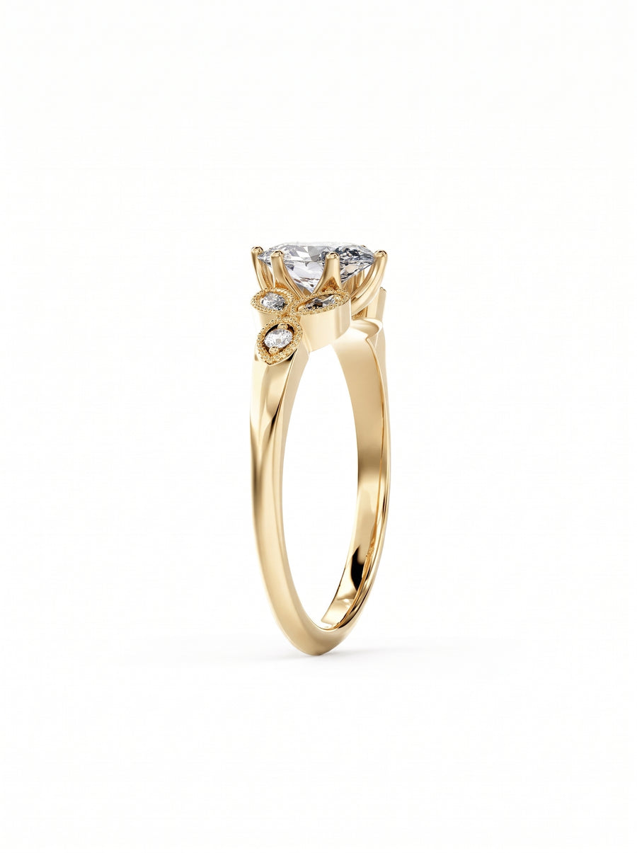 Oval cut diamond engagement ring in yellow gold with small accent stones and vintage milgrain detailing.