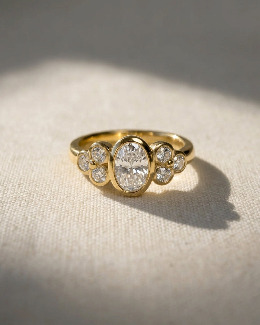 18ct yellow gold oval trefoil engagement ring with a central oval diamond and six round diamonds.
