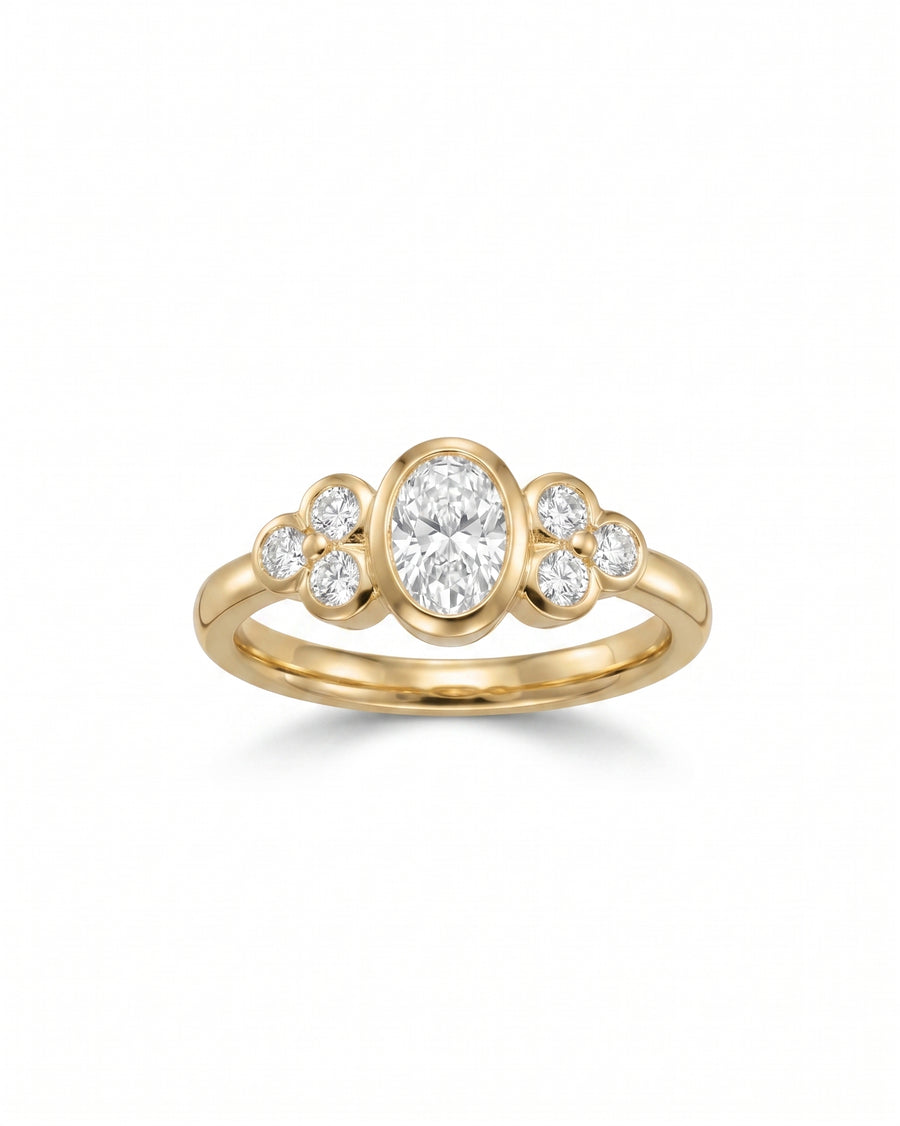 Gold oval trefoil engagement ring with a center oval diamond and six round diamonds.