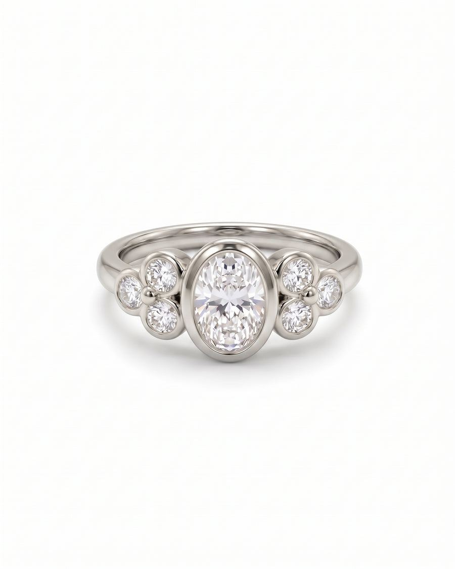 Oval diamond engagement ring in platinum with trefoil-style clusters of round side stones.