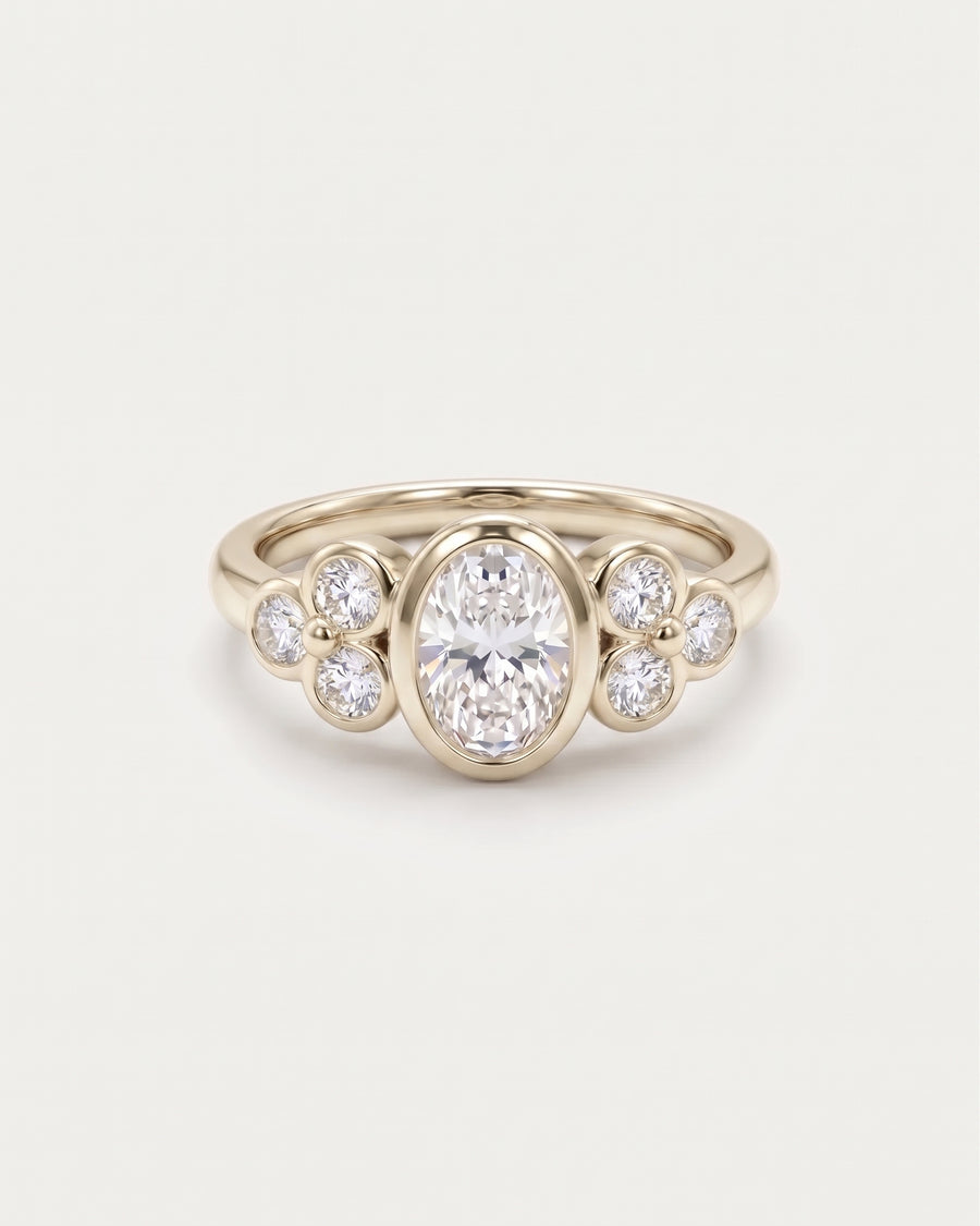 Oval diamond engagement ring in yellow gold with trefoil clusters of smaller round diamonds on each side.