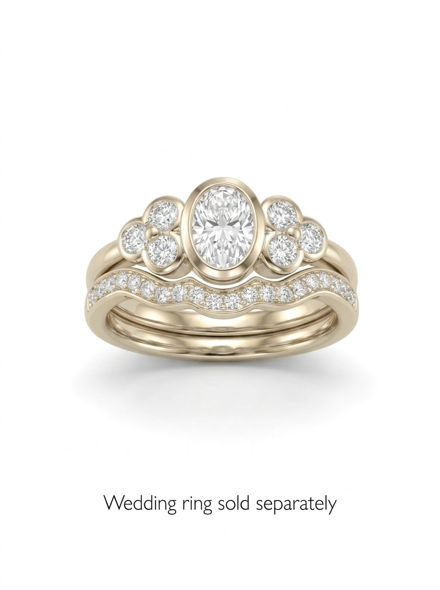 Oval diamond engagement ring in yellow gold with trefoil side stones and a matching diamond wedding band.