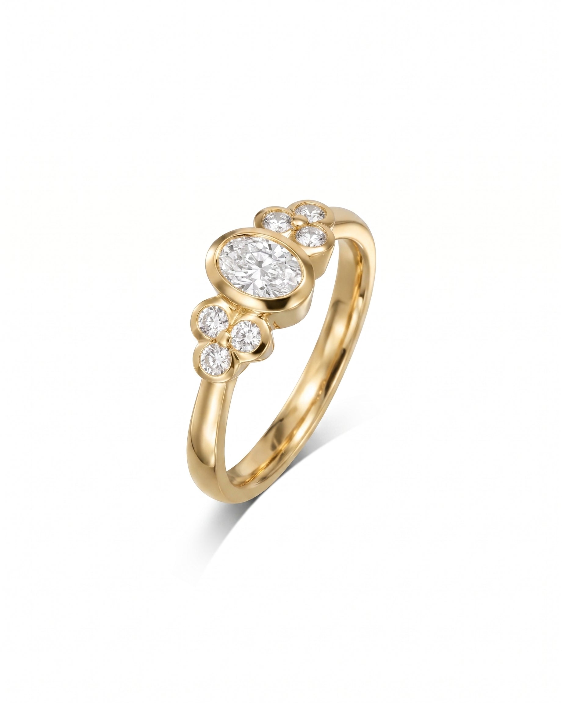 yellow Gold oval trefoil engagement ring with a central oval diamond and surrounding round diamonds.
