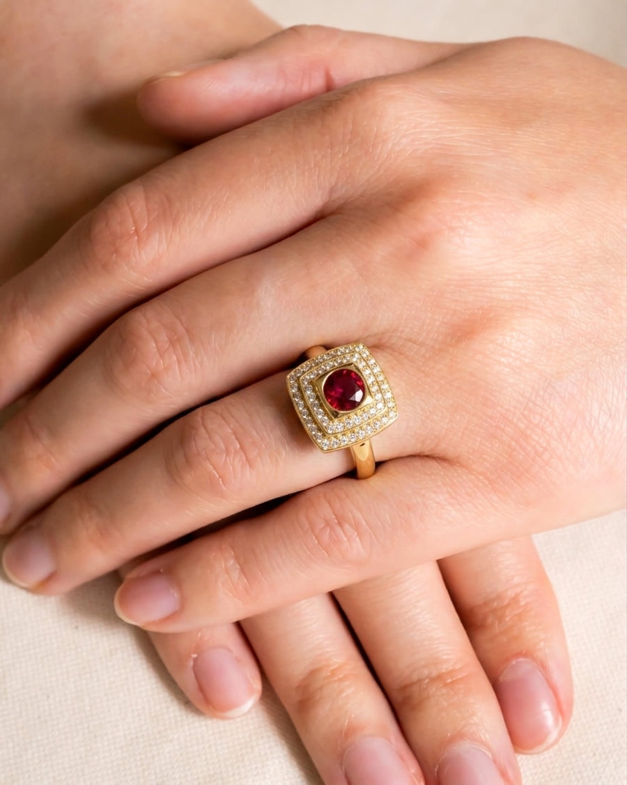 Yellow gold ring with a square ruby surrounded by two halos of diamonds.