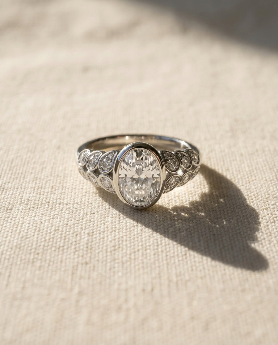 Silver paisley oval diamond engagement ring with side diamonds.