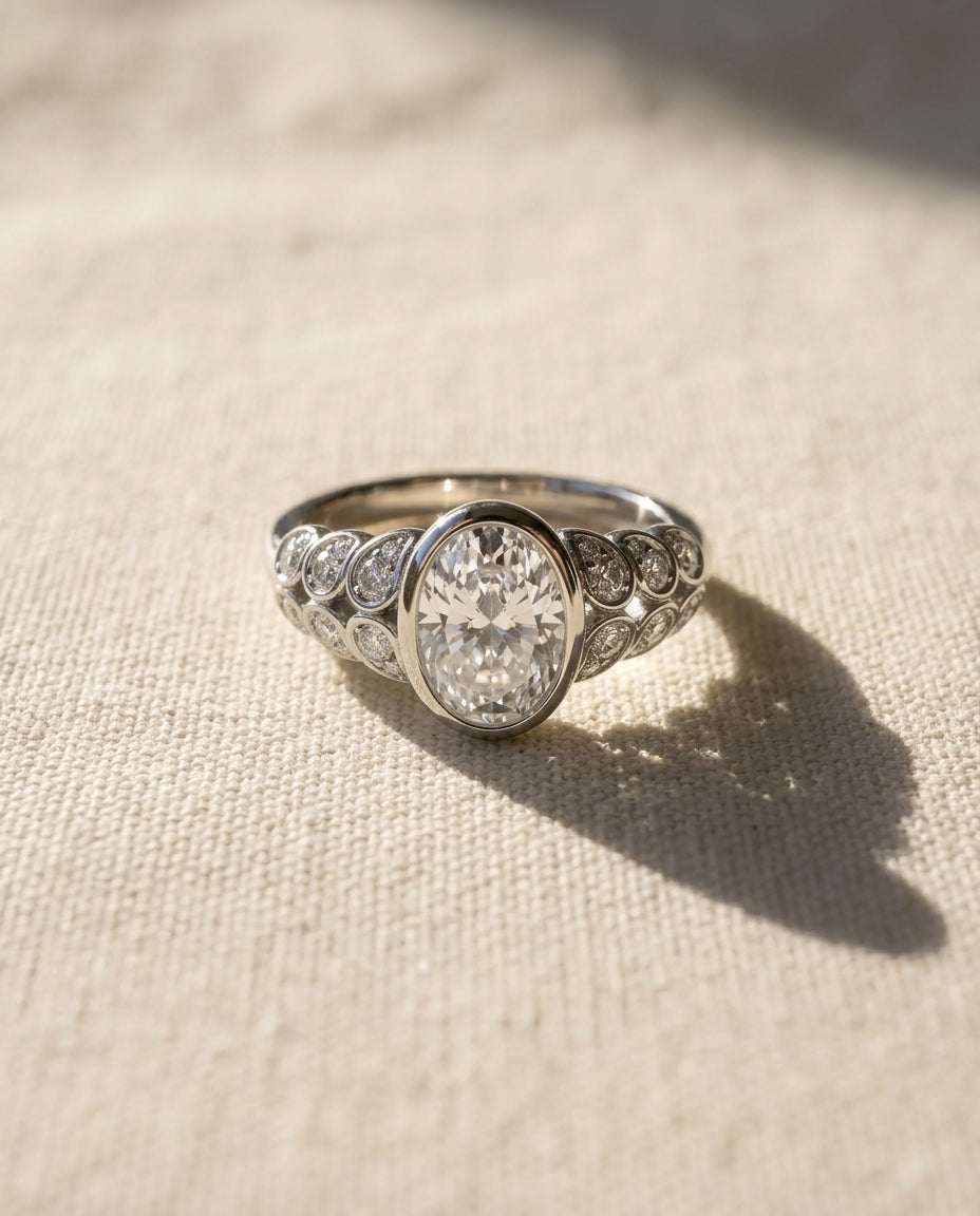 Silver paisley oval diamond engagement ring with side diamonds.