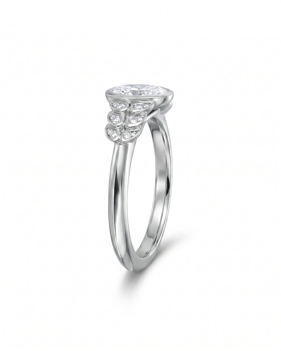White gold engagement ring with an oval diamond and paisley-shaped side diamonds.