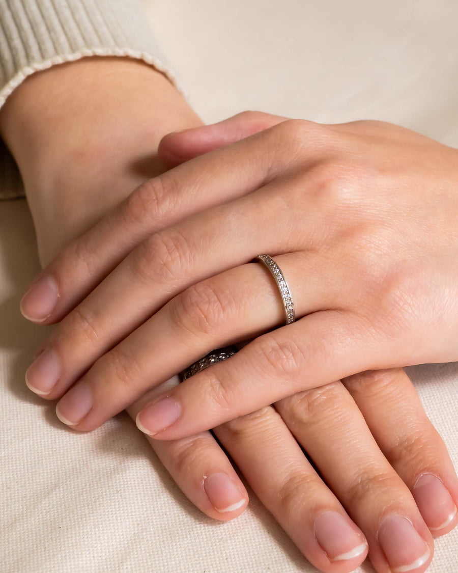 Silver pavé diamond ring on a hand.