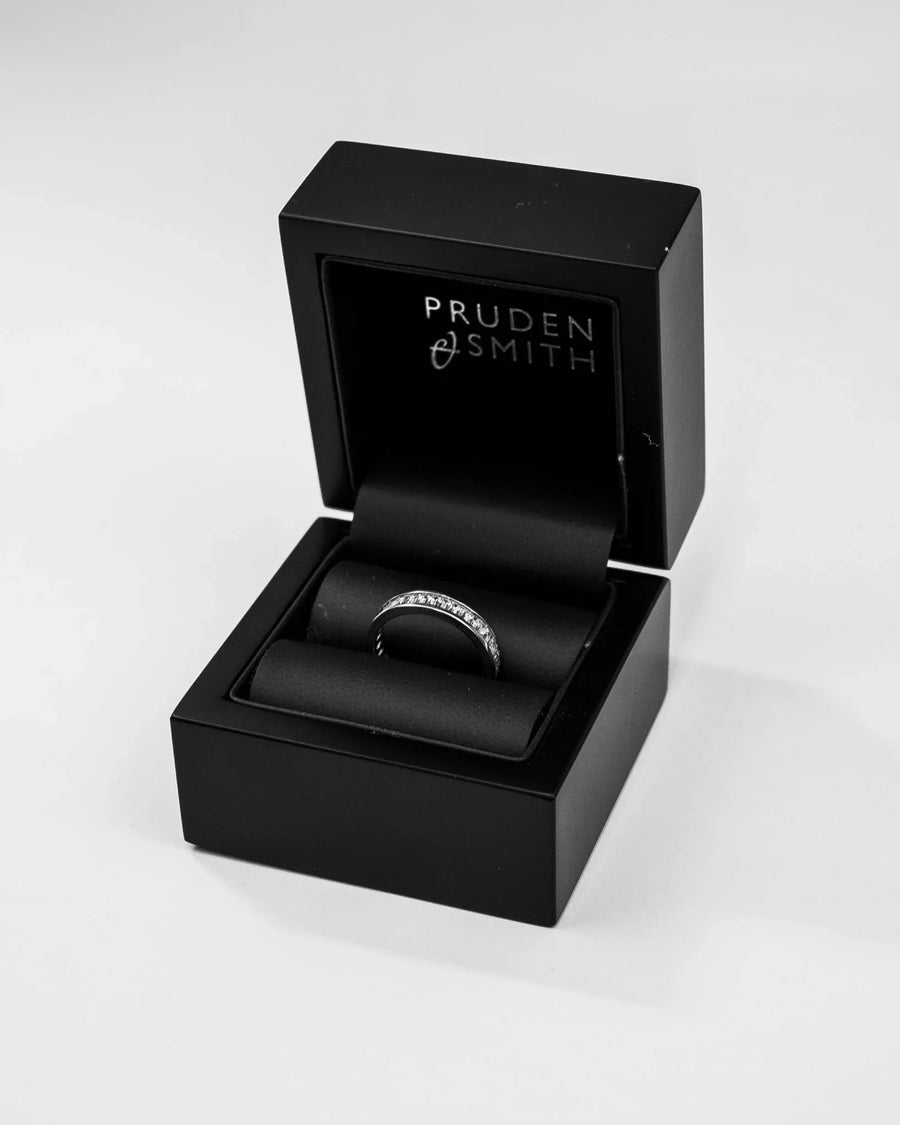 Silver pavé diamond ring in a black presentation box.