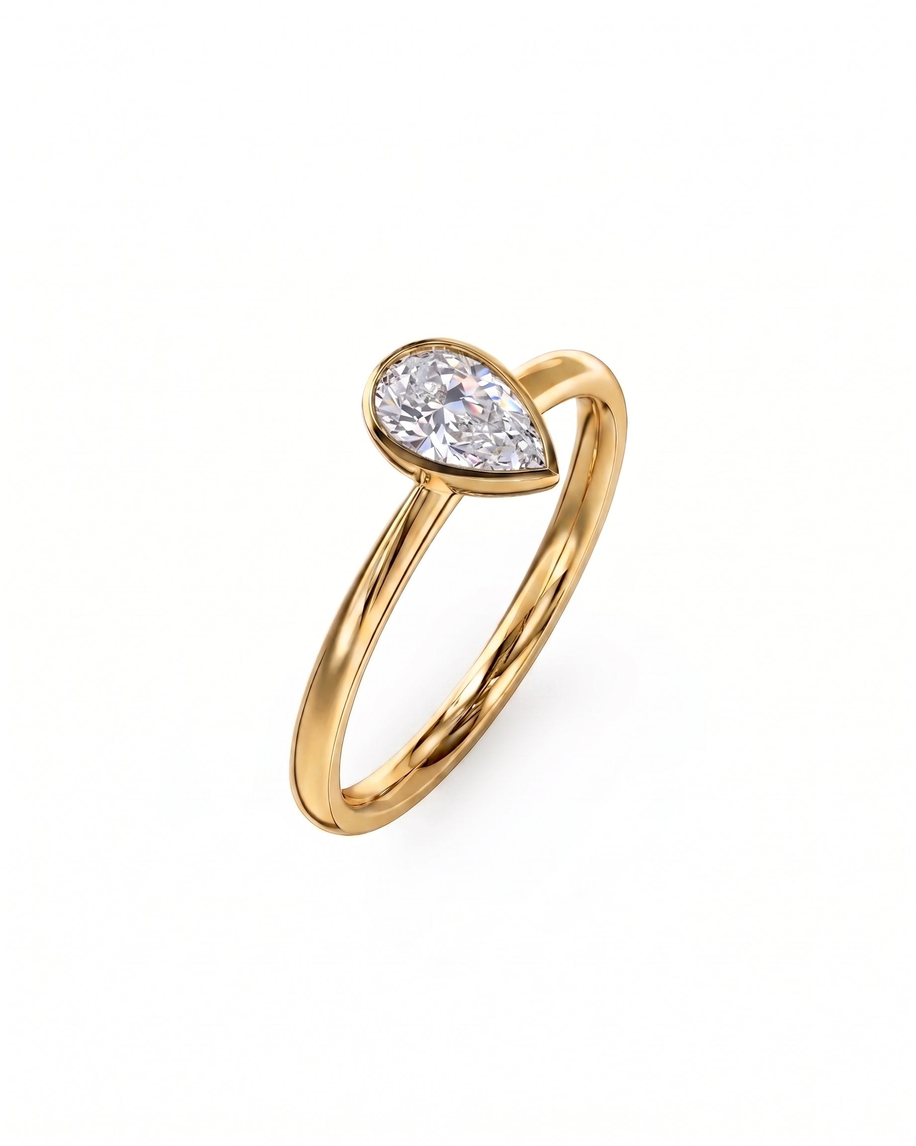 Gold engagement ring with a pear-cut diamond in a bezel setting.
