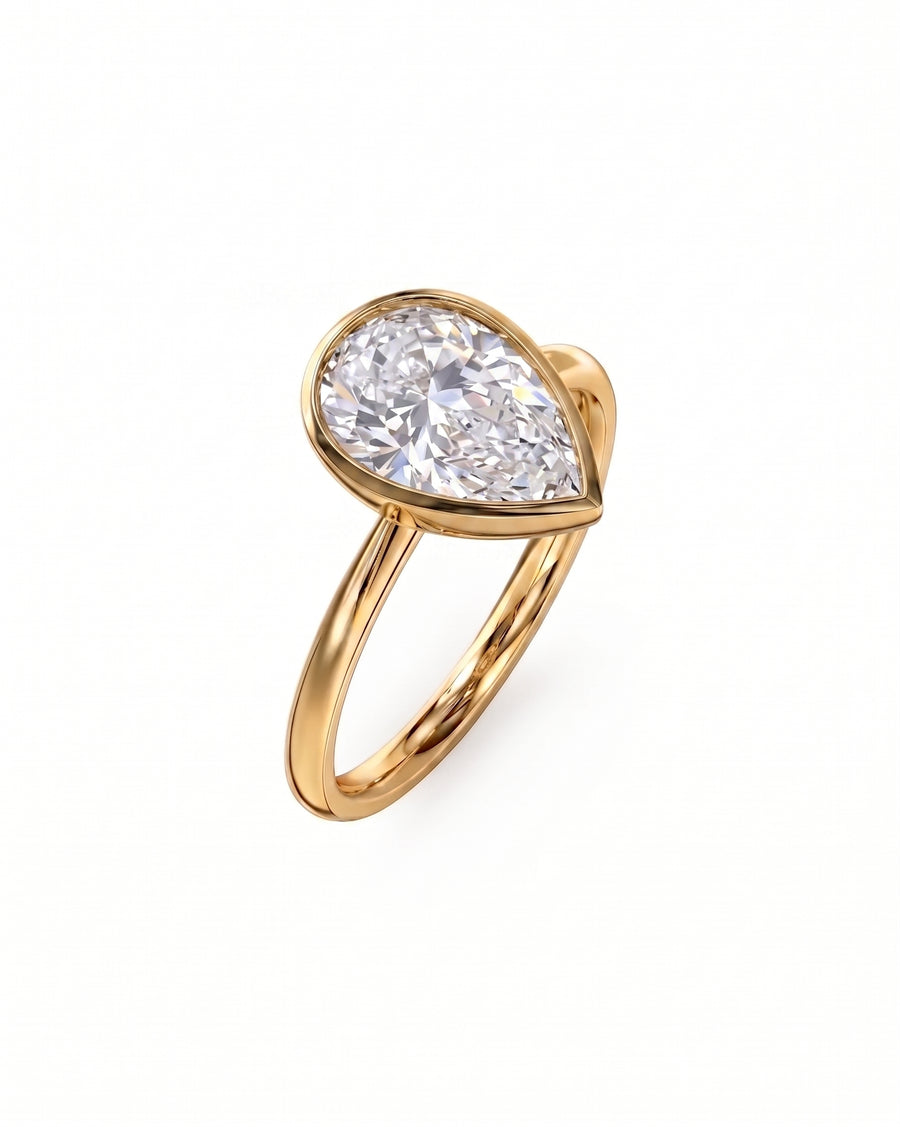 Gold pear cut bezel engagement ring with a large diamond.