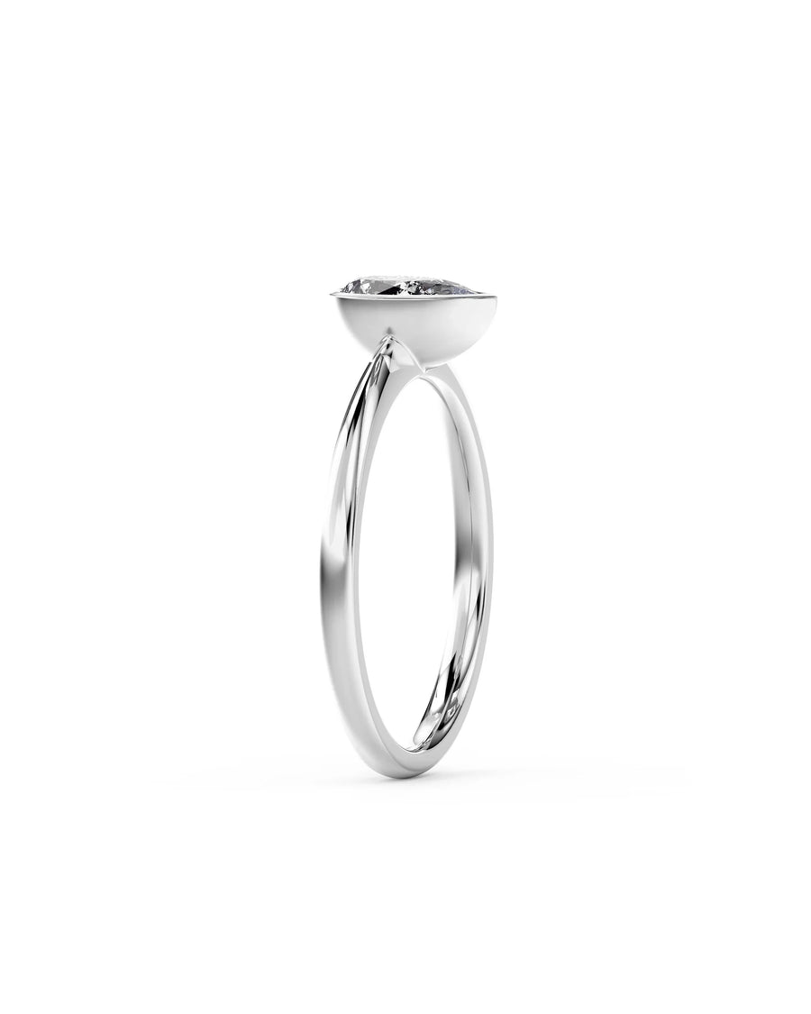 Silver pear cut bezel engagement ring with a diamond.