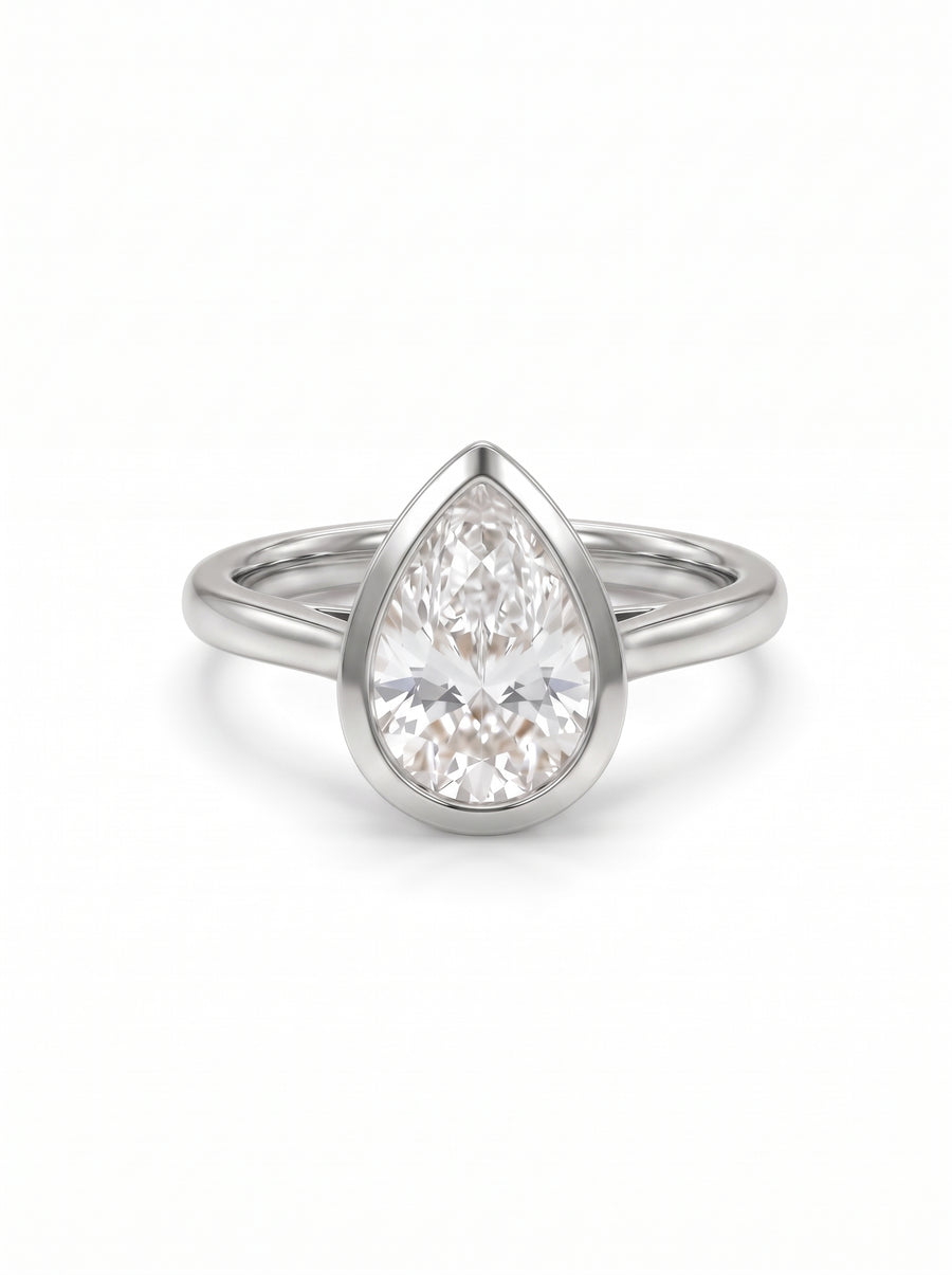 Pear cut diamond engagement ring in a platinum bezel setting on a plain band.