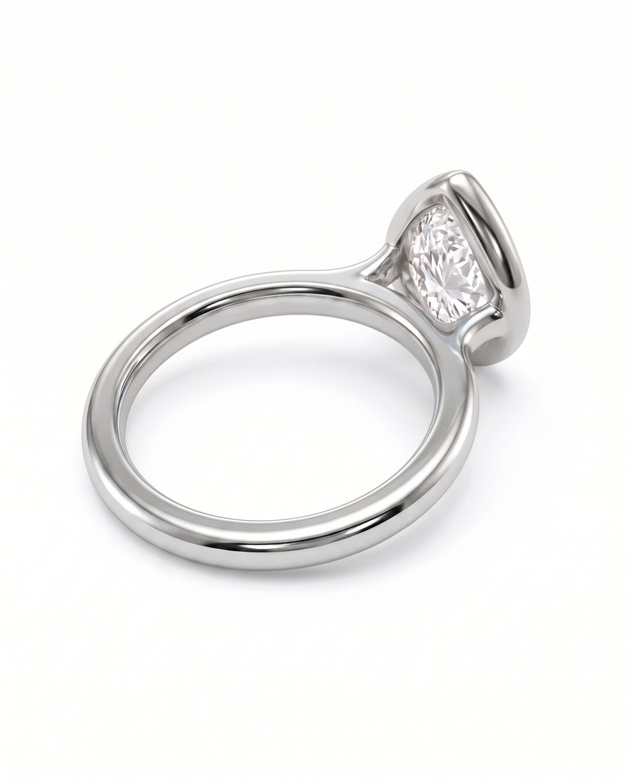 Pear cut diamond engagement ring in a polished silver-tone bezel setting on a plain band.