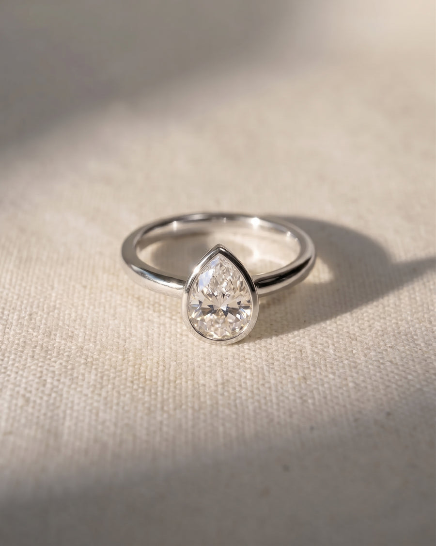 Platinum pear cut bezel engagement ring with a natural diamond.