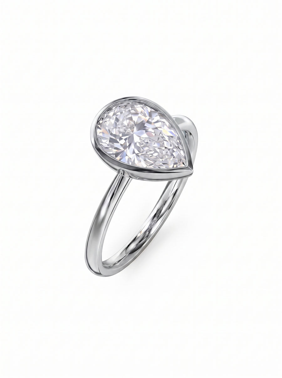 Pear cut diamond engagement ring in a silver-toned bezel setting on a polished metal band.