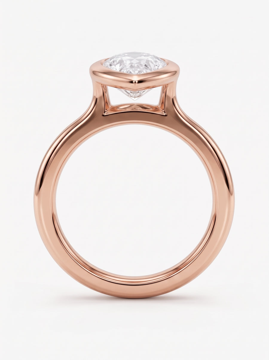Pear cut diamond engagement ring in a rose gold bezel setting on a white background.