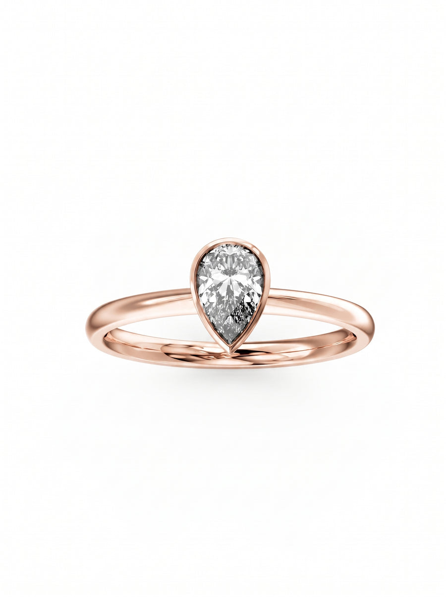 Pear cut diamond engagement ring in a rose gold bezel setting on a plain band.