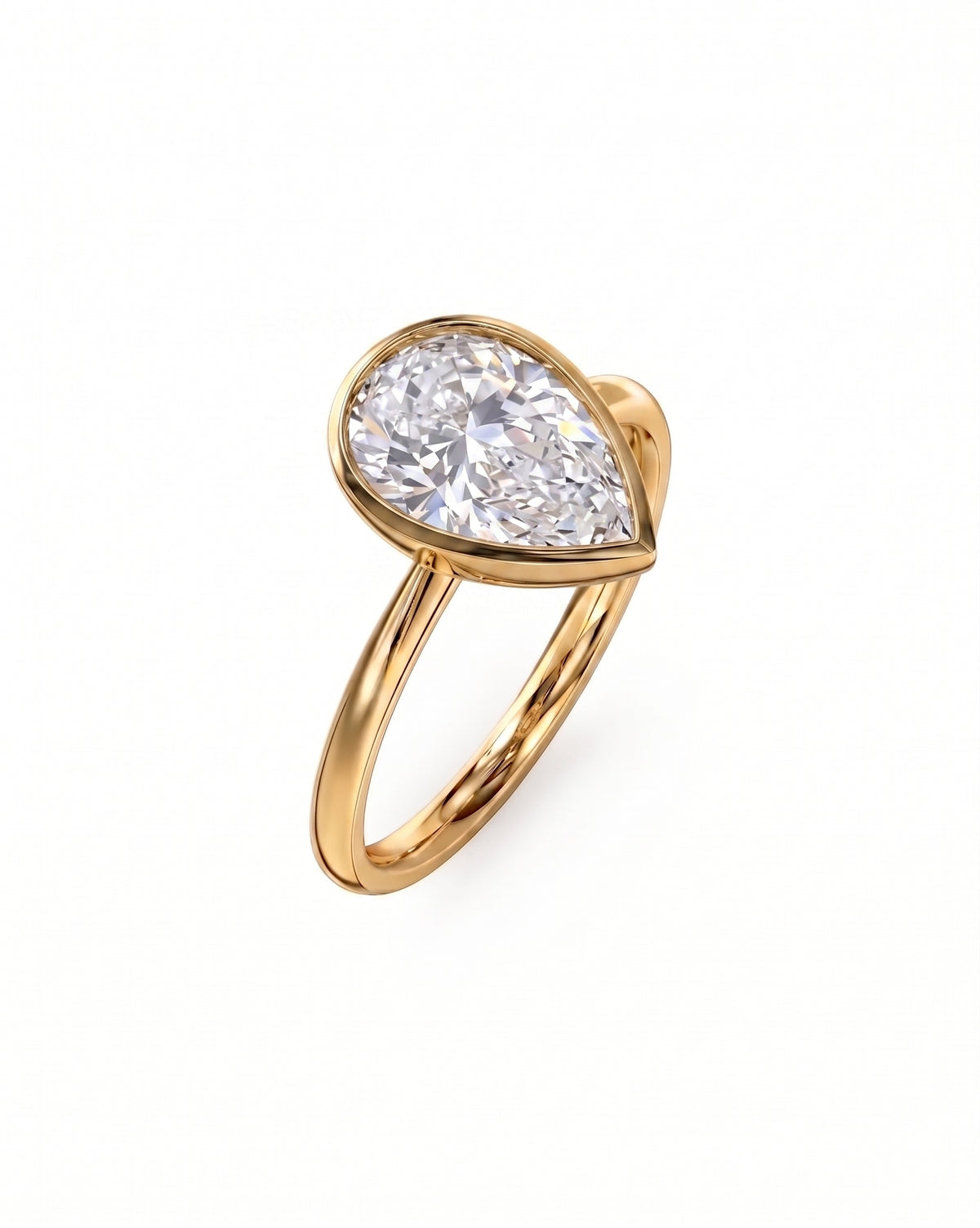 Pear cut diamond engagement ring in a gold bezel setting on a plain gold band.
