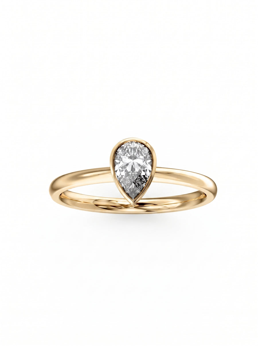 Pear cut diamond engagement ring in a yellow gold bezel setting on a plain band.