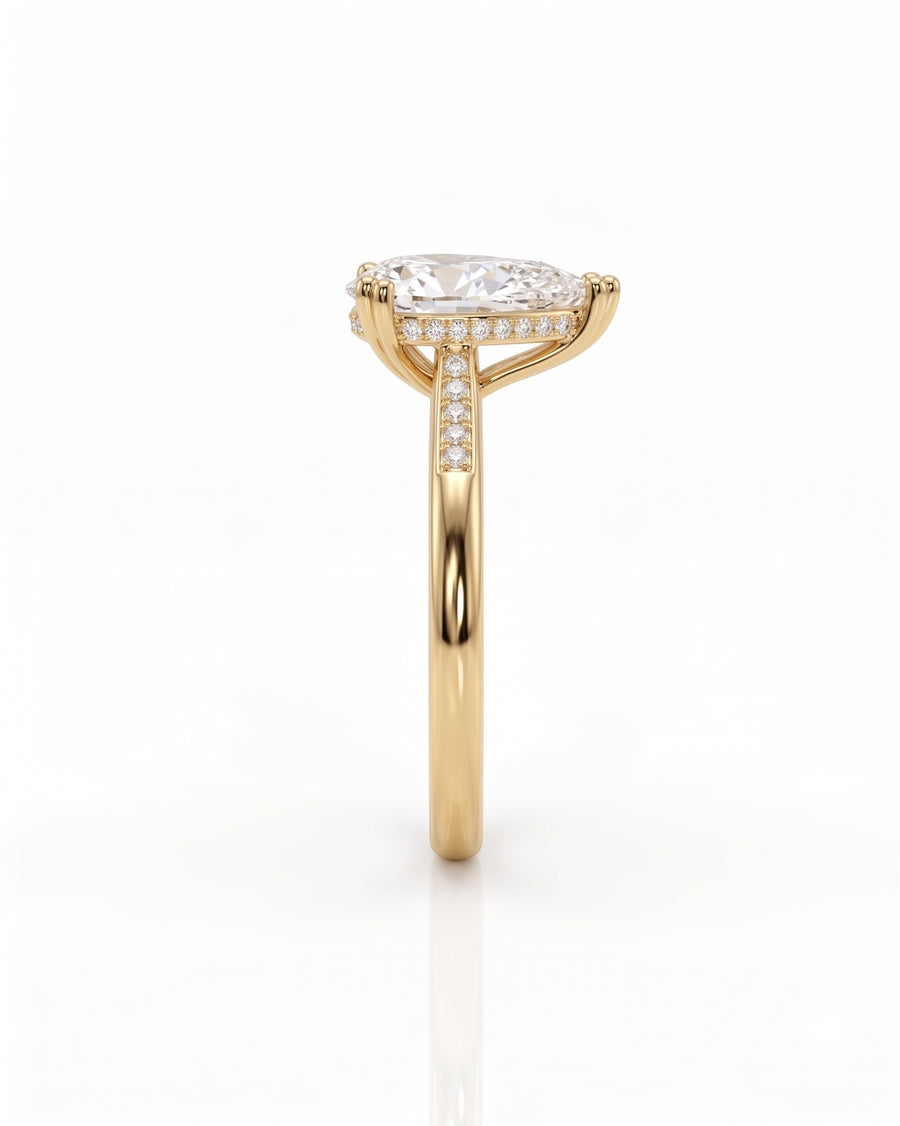 Yellow gold pear cut engagement ring with hidden halo and diamond band.