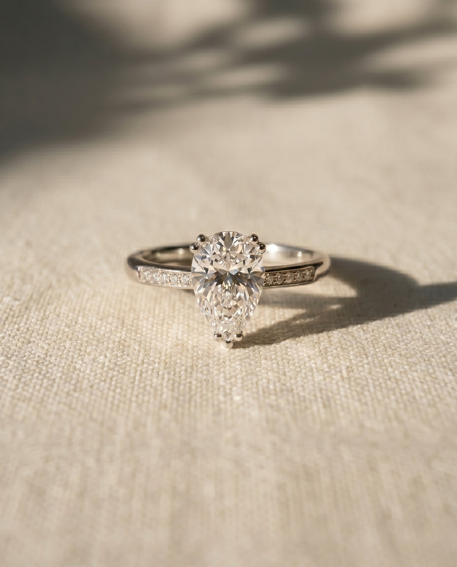 Platinum engagement ring with a pear cut lab grown diamond and hidden halo.