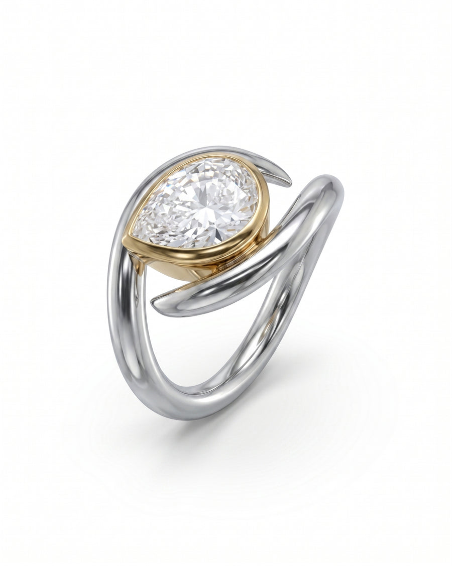Two-tone gold and silver ring with a pear-cut diamond in a spiky setting.