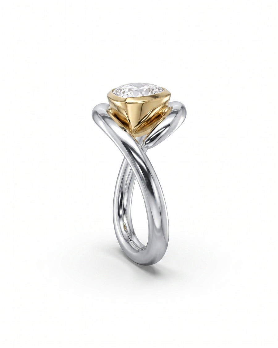 Two-tone gold and silver ring with a pear-cut diamond in a spiky bezel setting.