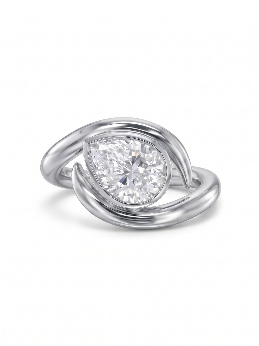 Platinum engagement ring featuring a pear cut diamond set within a curved, spiky metal band.