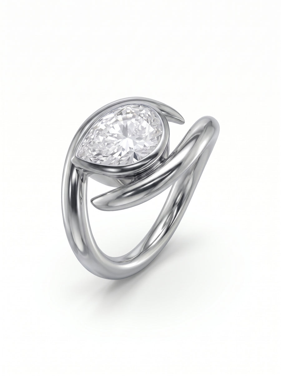 Pear-cut diamond engagement ring in a silver-toned metal band with a unique spiky, wrap-around design.