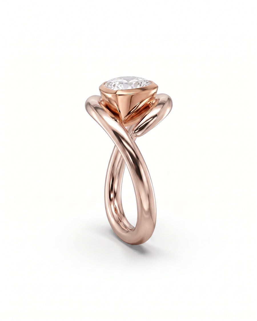 Rose gold engagement ring featuring a pear cut diamond set in a unique twisted, spiky metal band.