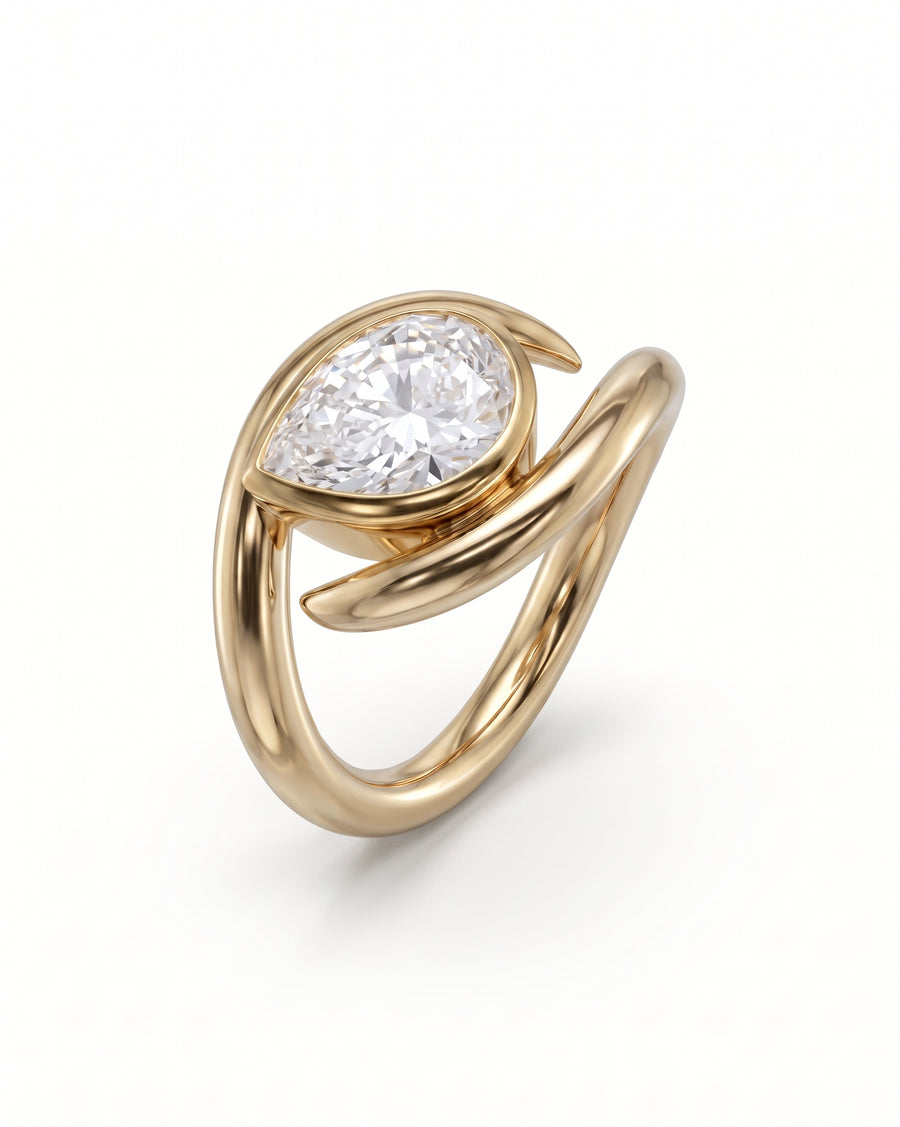 Gold engagement ring featuring a pear-cut diamond set in a unique, spiky wrap-around band design.