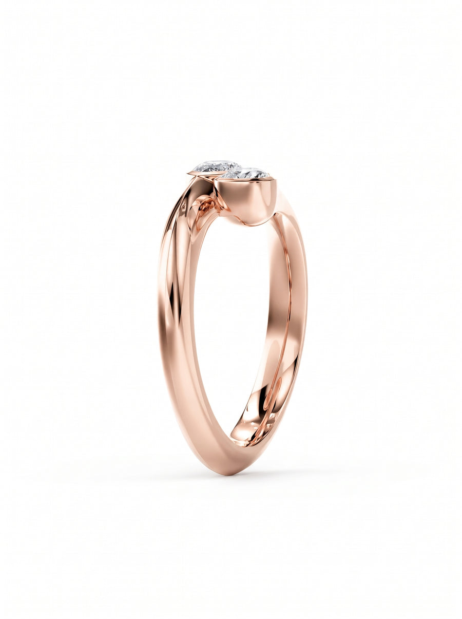 Rose gold toi et moi engagement ring featuring two pear cut diamonds in a bezel setting.