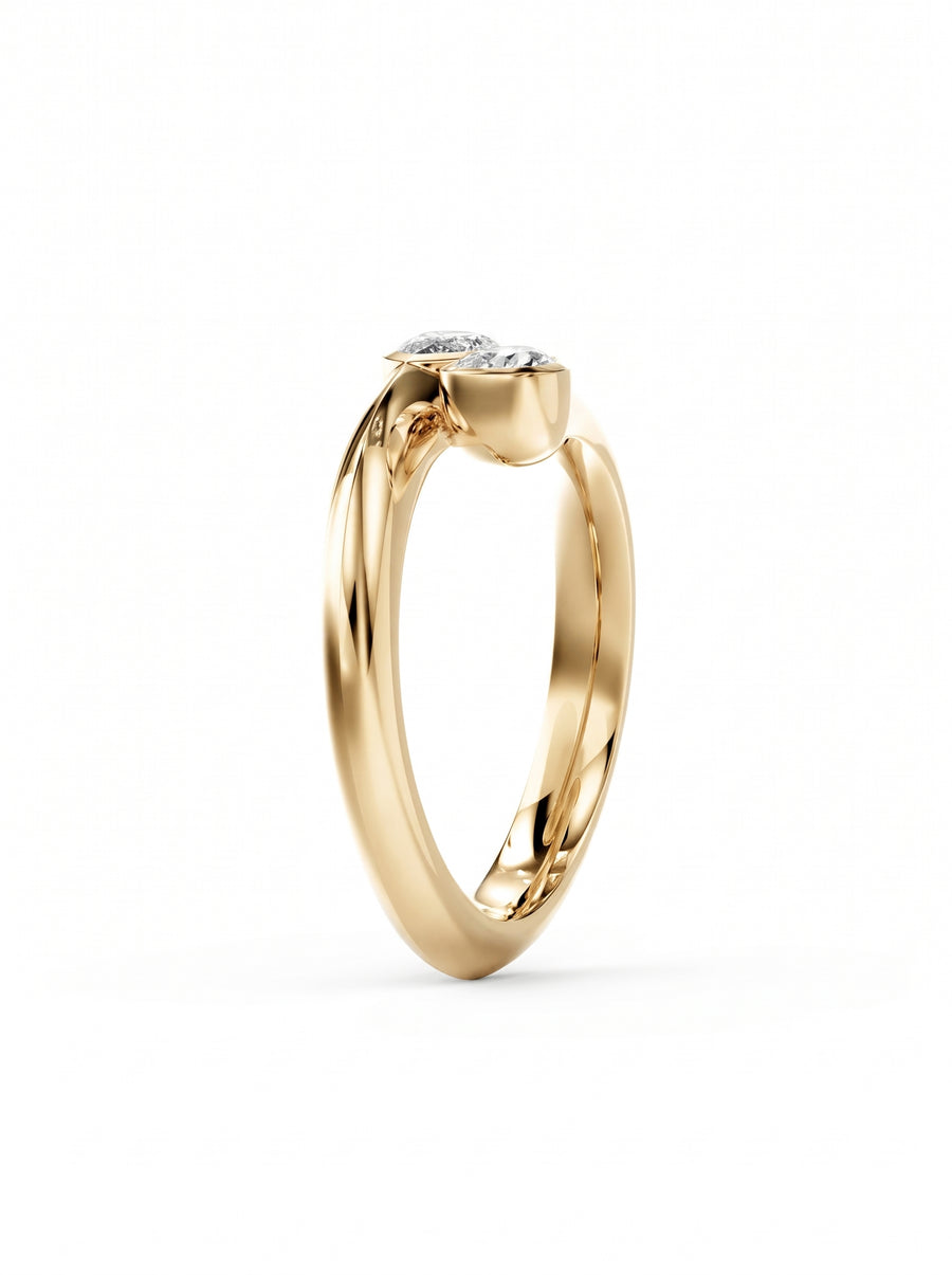 Gold toi et moi engagement ring featuring two pear cut diamonds in a bezel setting.