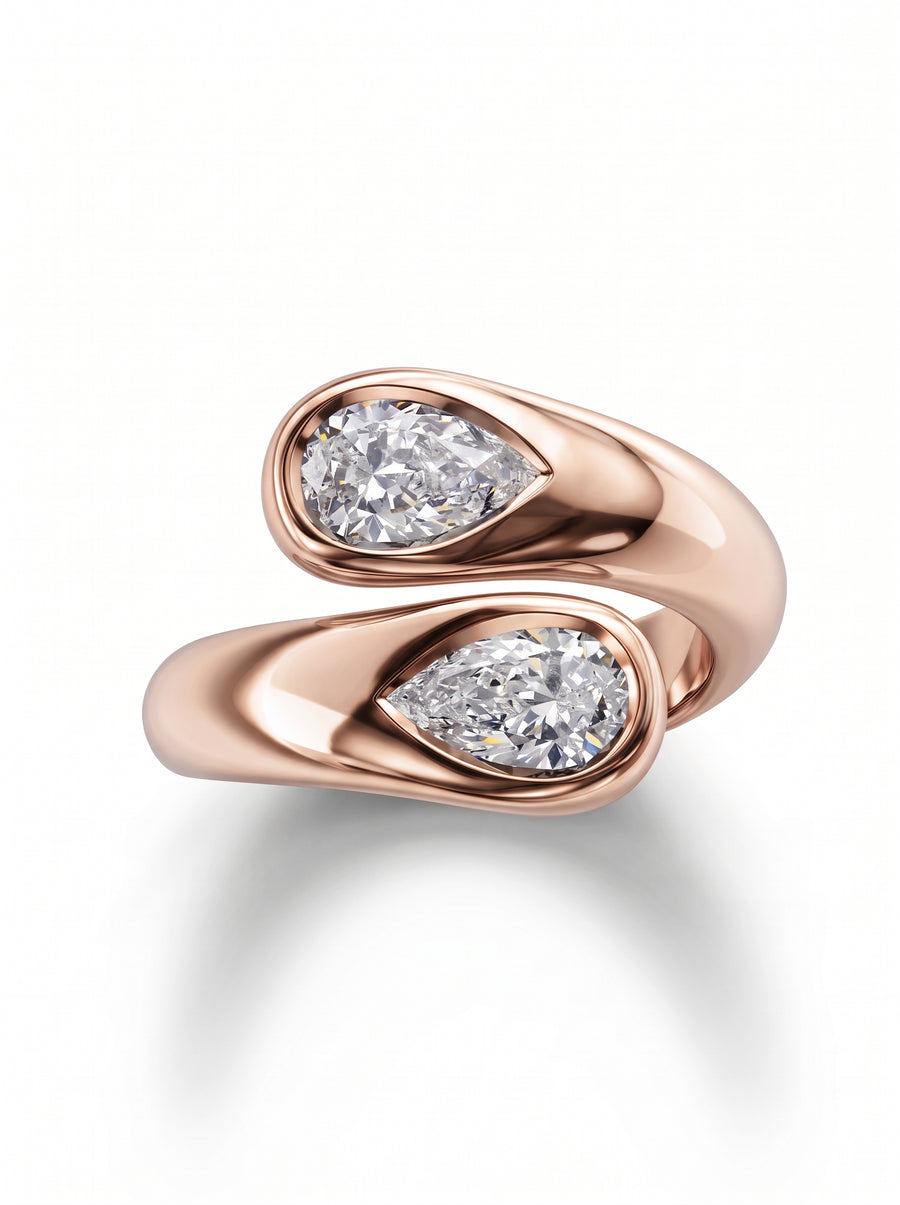 Rose gold toi et moi ring featuring two pear-cut diamonds in bezel settings.