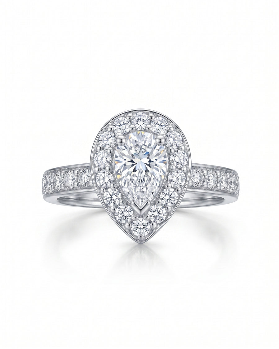 Silver ring with a pear-shaped diamond surrounded by a cluster of smaller diamonds.