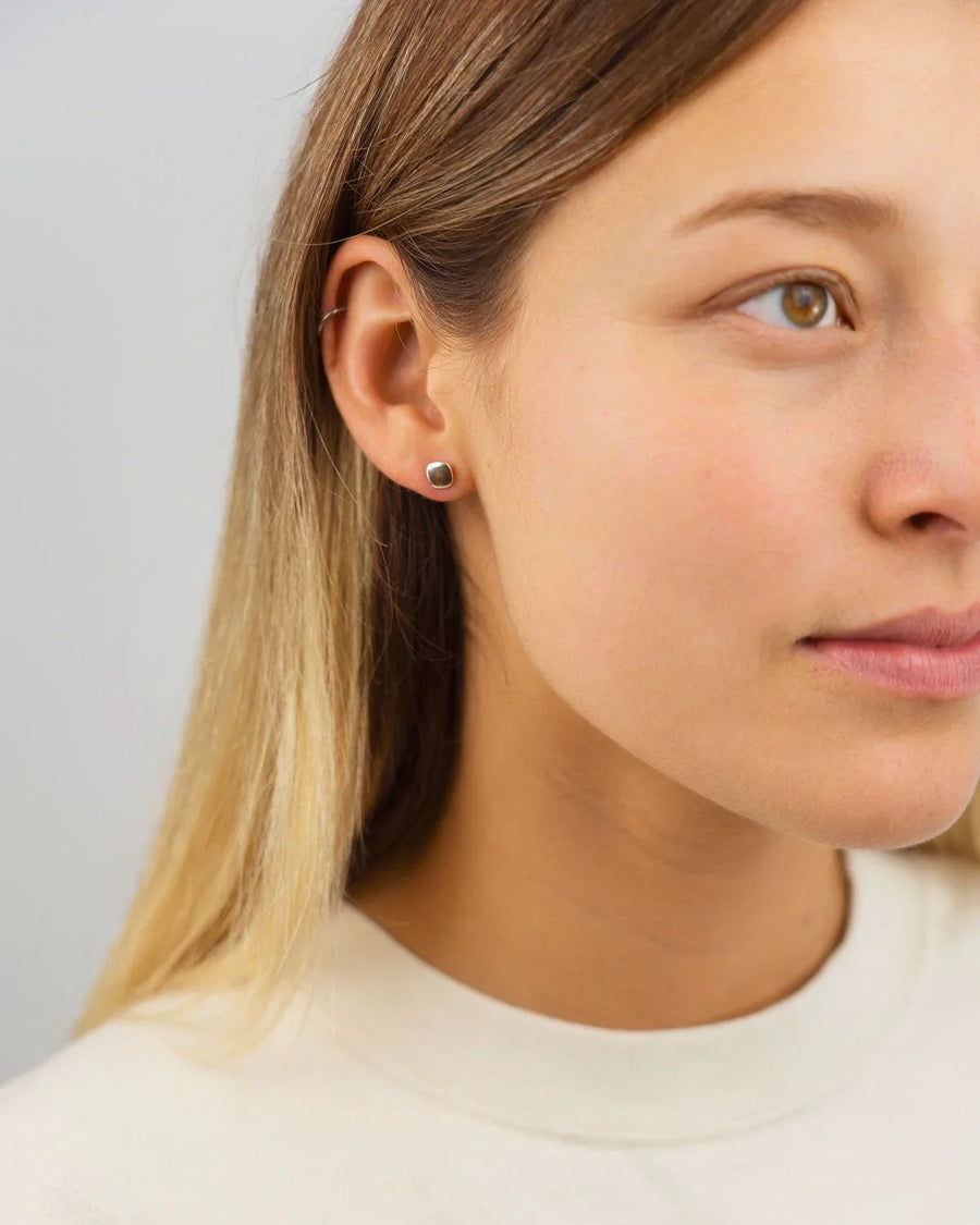 woman wearing minimalist silver pebble stud earrings