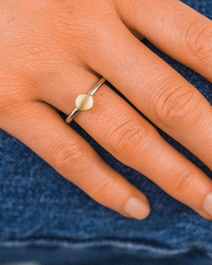 Matte gold stacking pebble ring with organic shape on a hand