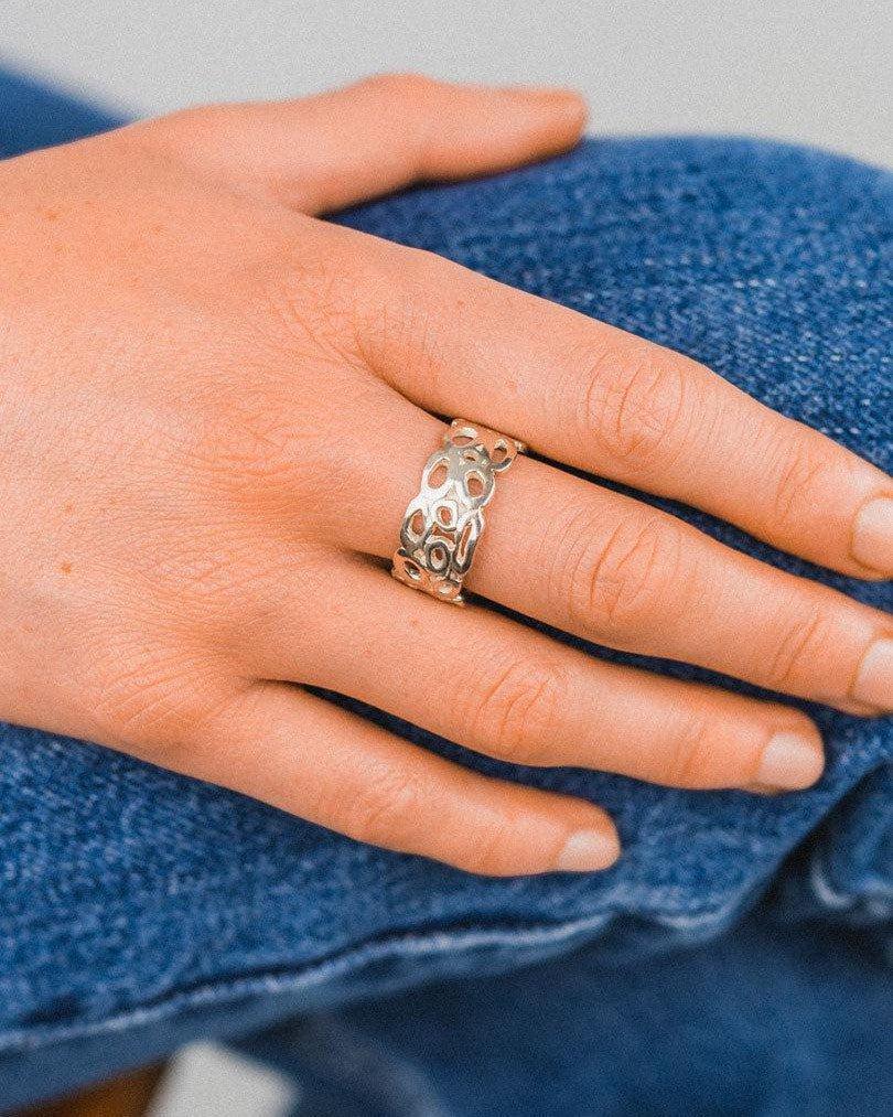 Silver wedding ring with an open pebble-like design.