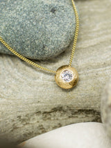 Gold nugget pendant on rock background