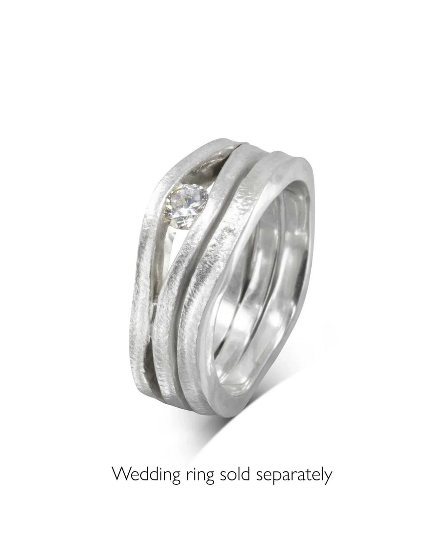 Platinum diamond trap solitaire engagement ring with a textured, wavy band.