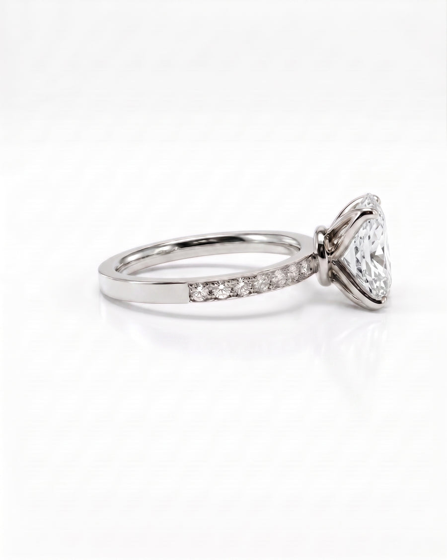 A platinum diamond ring featuring a large triangular center stone and a pavé band with small diamonds, shown on a clean white background.