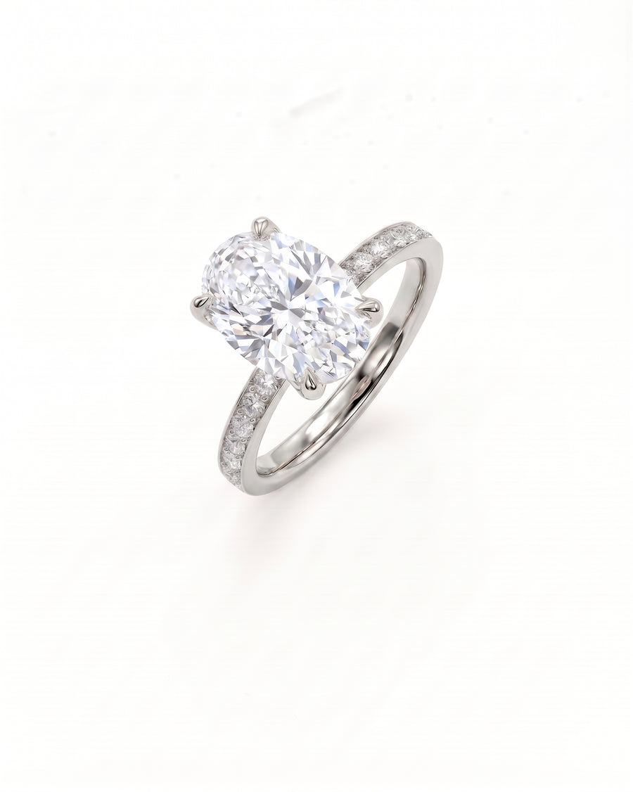 A platinum diamond engagement ring featuring a large oval-cut center stone and a pavé-set band, shown on a clean white background.