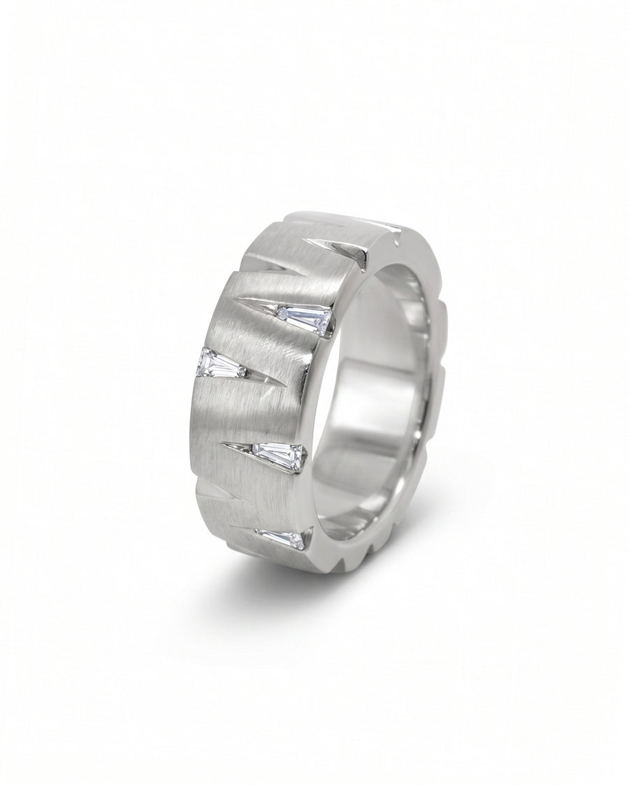 Brushed platinum band ring featuring triangular cutouts with inset baguette diamonds.