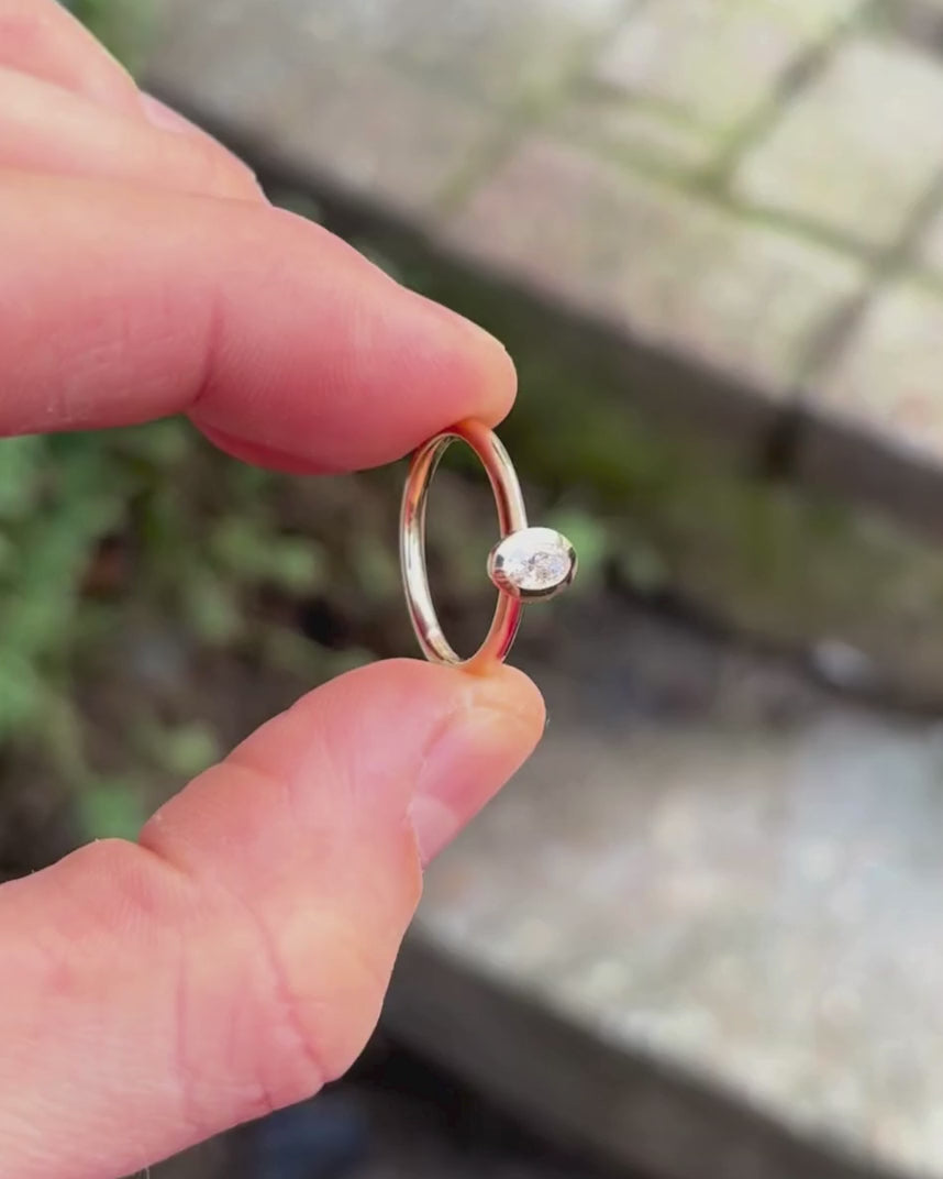 oval bezel engagement ring being rotated by hand