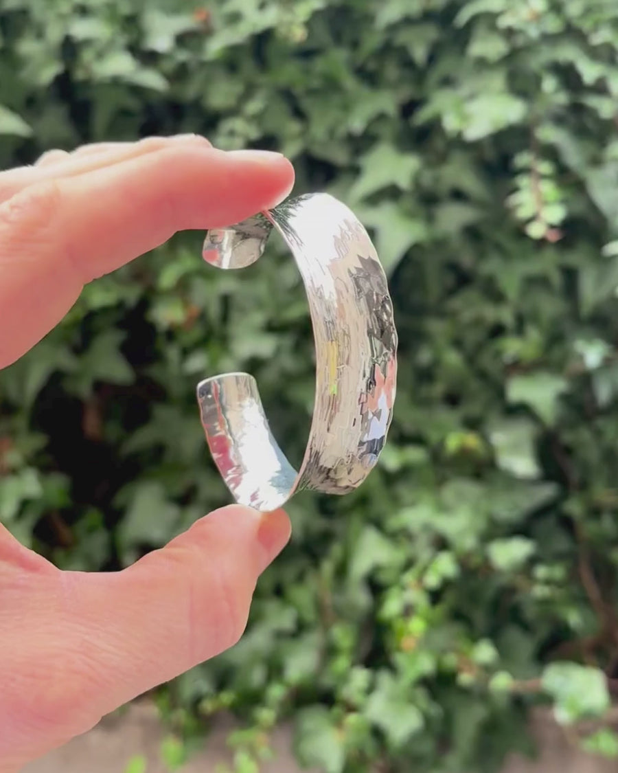 chunky silver bangle being held