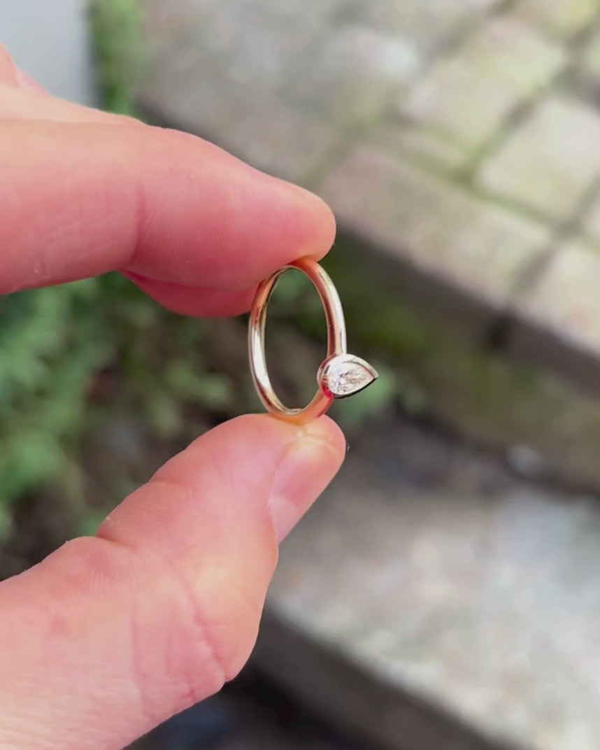 pear cut bezel engagement ring being rotated