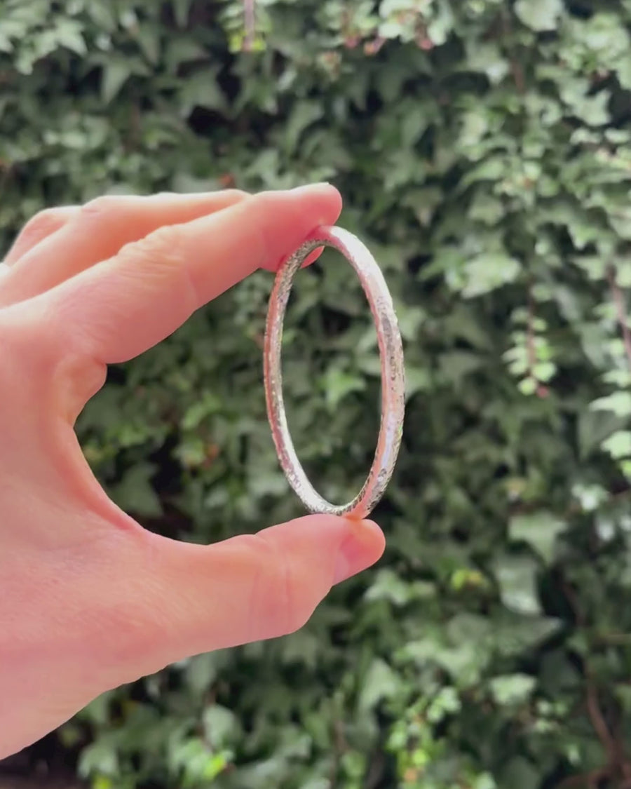 solid silver round bangle hammered being rotated