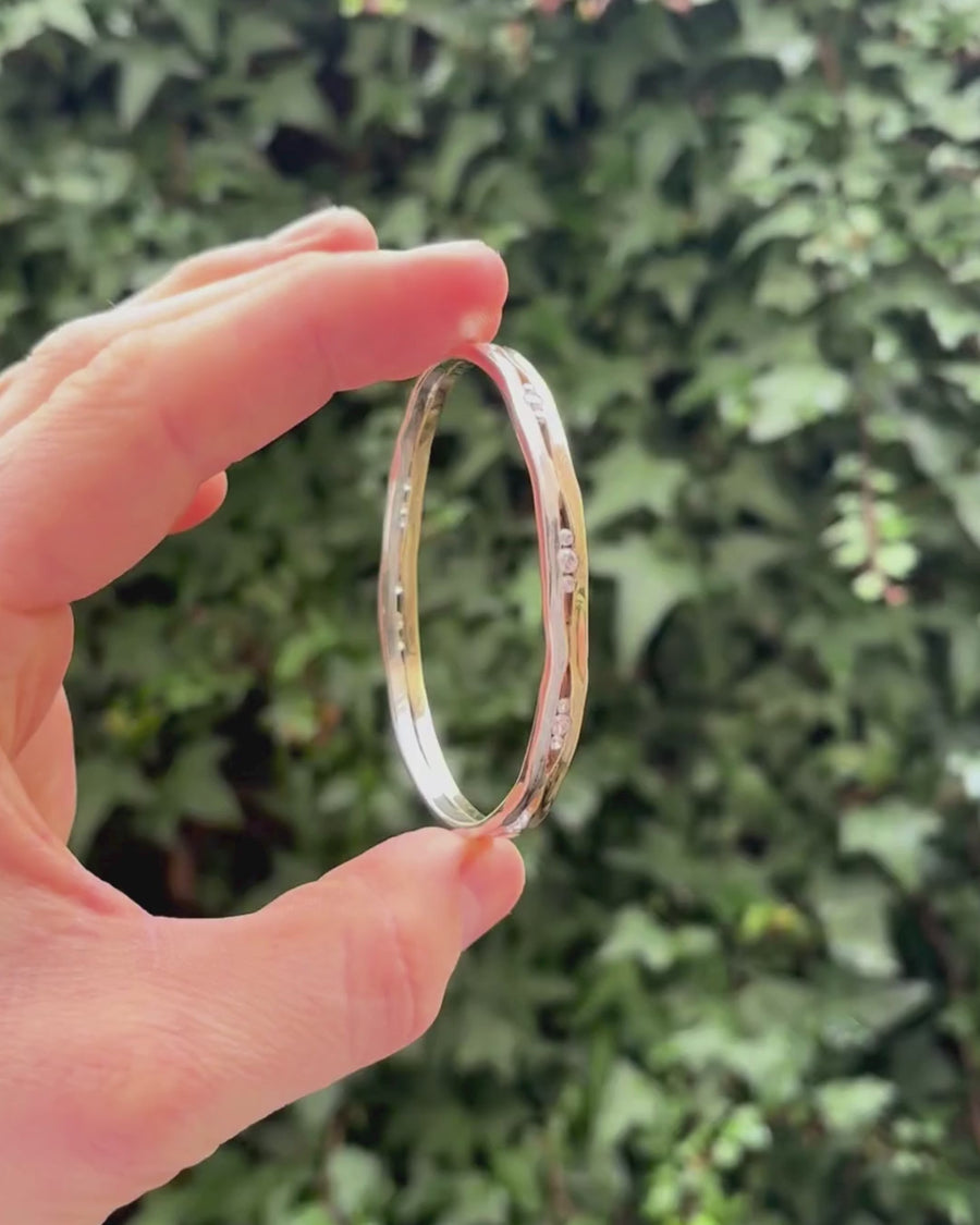 trap mixed metal bangle being held